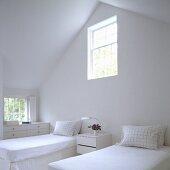 Weisser Schlafraum - Einzelbetten unter Dach mit Fenster in der Giebelwand