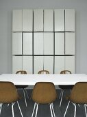 A conference table with brown bucket chairs and a tailor-made wall cupboard with open doors