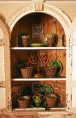 Crockery in an arched corner cupboard with its door open