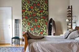 Bedroom with antique wooden bed and wall hanging with floral pattern and chair in Art Nouveau style