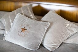 Bright gray pillows with embroidery on a bed