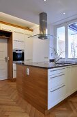 Extractor fan above central island unit in contemporary kitchen
