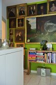 Ahnengalerie auf grüner Wand und halbhohes Bücherregal