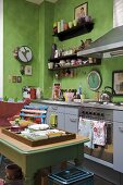 Ländlicher Küchentisch in moderner Küche mit grüner Wand