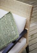 A detail of a woven cane chair with woven cushion,