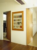 Bücherregal mit Holzrahmen und offene Türen im Flur