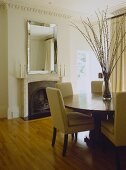 A modern, neutral dining room, round table with upholstered chairs, fireplace, wood floor,