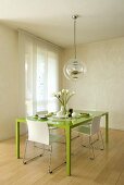 Grüner Esstisch mit Stühlen und Hängelampe im Designerstil