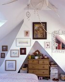 Bedroom in a converted attic with wood chest-of-drawers in a wall niche