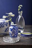 Chinese vases with white and blue painted decoration and white larkspur in glass vases