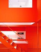 Offenes Treppenhaus mit Blick auf moderne Küche in Rot