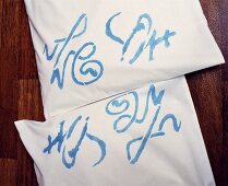 Blaue Schriftzeichen auf weisser Kissenhülle