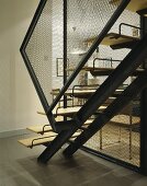An open staircase with metal stairs and a banister with chicken wire