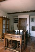 weiße Teekanne und Schalen auf antikem Holztisch mit passenden Stühlen in französischem Landhaus-Esszimmer