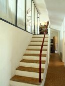 Rustikaler, gemauerter Treppenaufgang in Gangflucht mit moderner Glastrennwand und Terracotta-Kleinstein auf Stufen und Boden