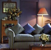Ein violettes Wohnzimmer, das mit einer gemusterten Couch eingerichtet wurde