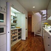 Eine offene moderne Küche mit einem Einbauschrank und eine Wendeltreppe