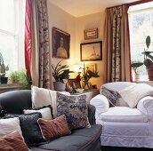Sofa und weisser Polstersessel mit Kissen im Wohnzimmer