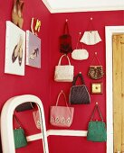 Handtaschensammlung an in Zimmerecke mit roter Wand
