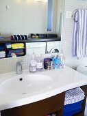 Ein weisser Waschtisch und Badeutensilien in einem Badezimmer