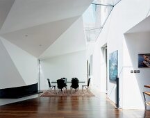 Futuristischer Wohnraum mit schwarzen Essstühlen und Tisch unter gefalteter Decke