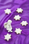 Cinnamon stars and an angel figurine on a purple surface