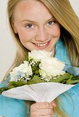 Young girl holding bouquet of white roses in her hands