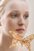 Young blond woman with an artificial butterfly