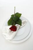 Place-setting with red rose