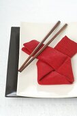Asiatisches Gedeck mit roter Serviette und Essstäbchen