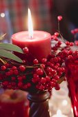Red candle with berries