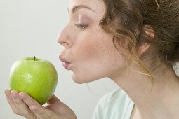 Frau hält grünen Apfel