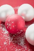 Red and white Christmas baubles with artificial snow