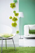White wall with green flowers and cushion on chair