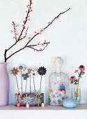 Blühender Frühlingszweig in einer Vase neben Dekoobjekten