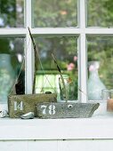 Homemade sailing boats made of driftwood as decoration on a windowsill