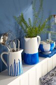 Hand-painted porcelain jugs and bowls in blue-and-white on a wall shelf in a kitchen