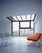 Cooles Design - weisser Schalenstuhl und rotes Sofa im Designerstil vor Fensterfront mit Oberlicht in Decke