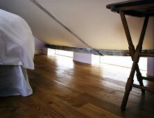 Sleeping area under a pitched roof and old wooden floor