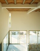 Minimalistischer Wohnraum in weisser Villa mit Terrassenfenstern