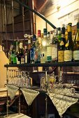 Verschiedene Getränke in Flaschen und Gläser an einer Bar