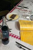 Speisekarte, Rotwein und Dessert auf einem Tisch in einem Restaurant