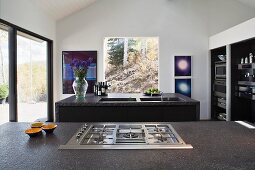 Gasherd in grauer Steinplatte vor freistehender Kücheninsel mit grauer Steinplatte in moderner Küche
