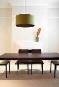A classic-modern dining room with a retro pendent lamp about a dark wooden table