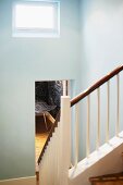 Weiß lackiertes Holzgeländer im Treppenhaus und offene Tür