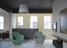 Moderne hellgraue Korbsessel im offenen Wohnraum und klassischem Ambiente