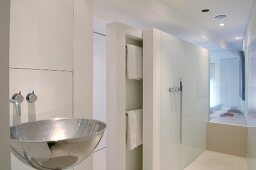 Glaswand und Schiebefront mit integrierten Handtuchstangen zwischen Schlafzimmer und zeitgenössischem, weißem Bad