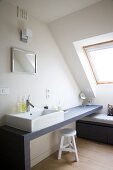 Optimal genutzte Dachschräge - Bad im schlichten skandinavischen Stil mit rechteckigem Aufsatzbecken auf graublauer Waschtischplatte und Stauraum unter einer Sitzbank
