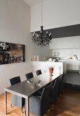 Dining table and grey, rattan basketwork chairs in modern kitchen