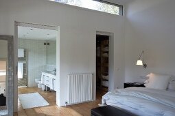Bedroom with long, slot-shaped transom window, adjacent dressing room and en suite bathroom